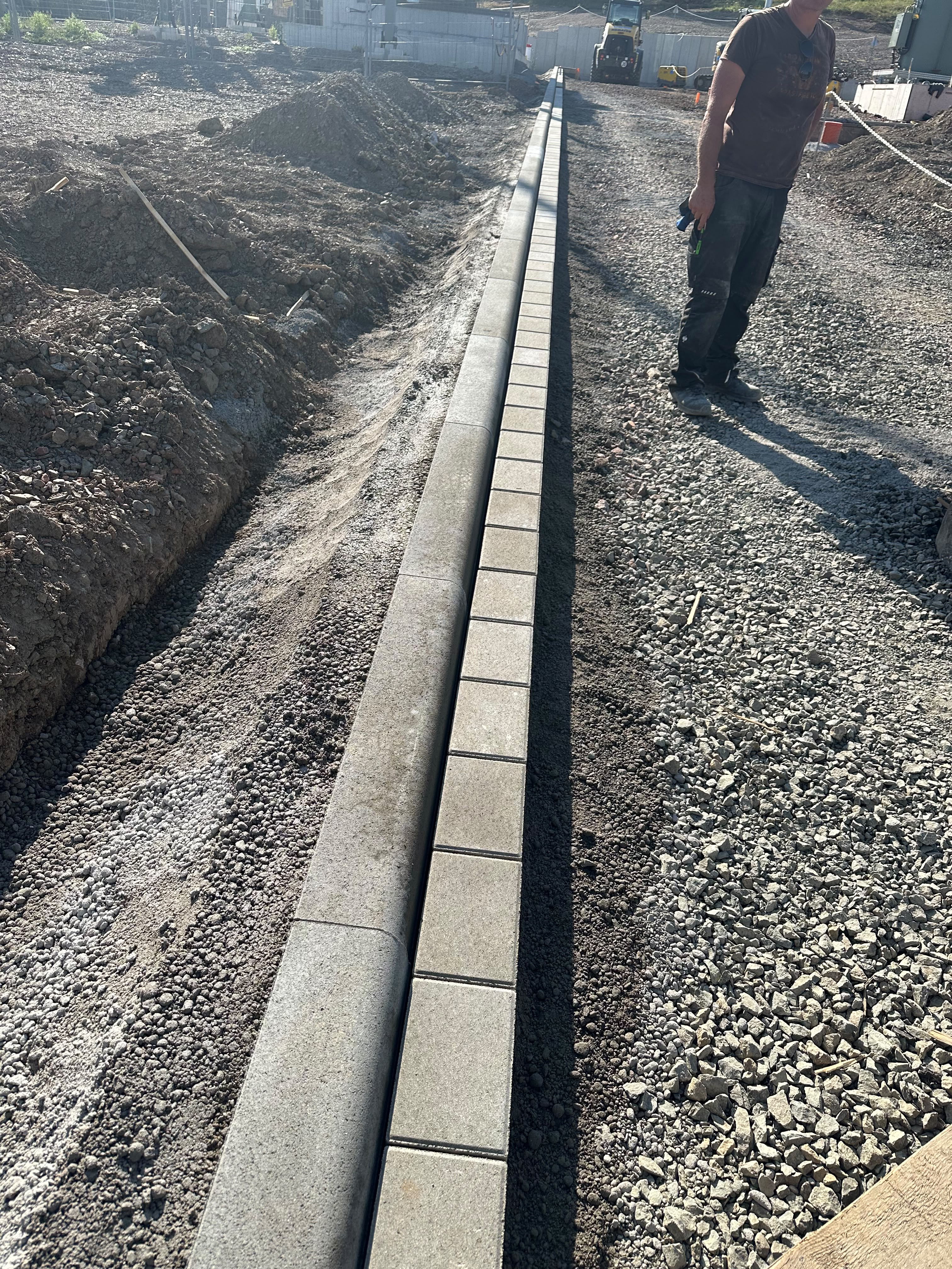 In Beton gesetzte Entwässerungsrinne entlang einer Baustelle