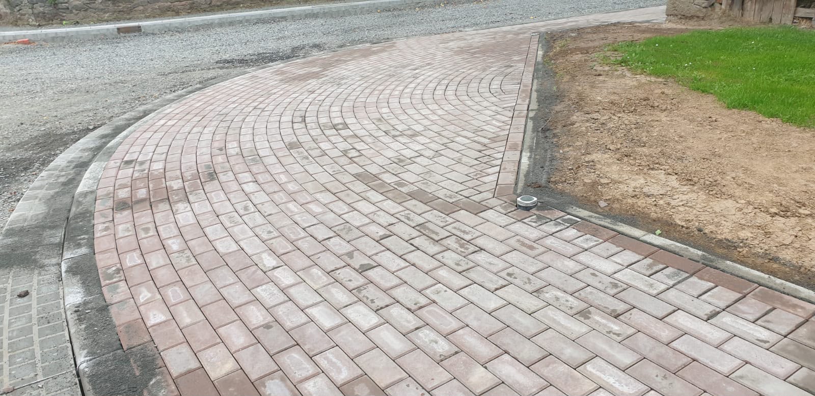 Geschwungene Pflasterfläche mit roten Bögen